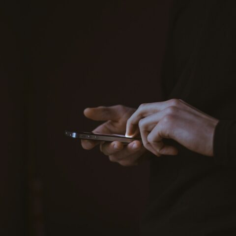 silhouette photo of person holding smartphone